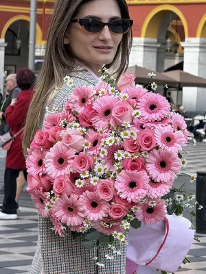 Lifestyle photo of Sweet Pink Romantic Flowers Bouquet held outdoors, showcasing pink gerberas and roses in natural setting