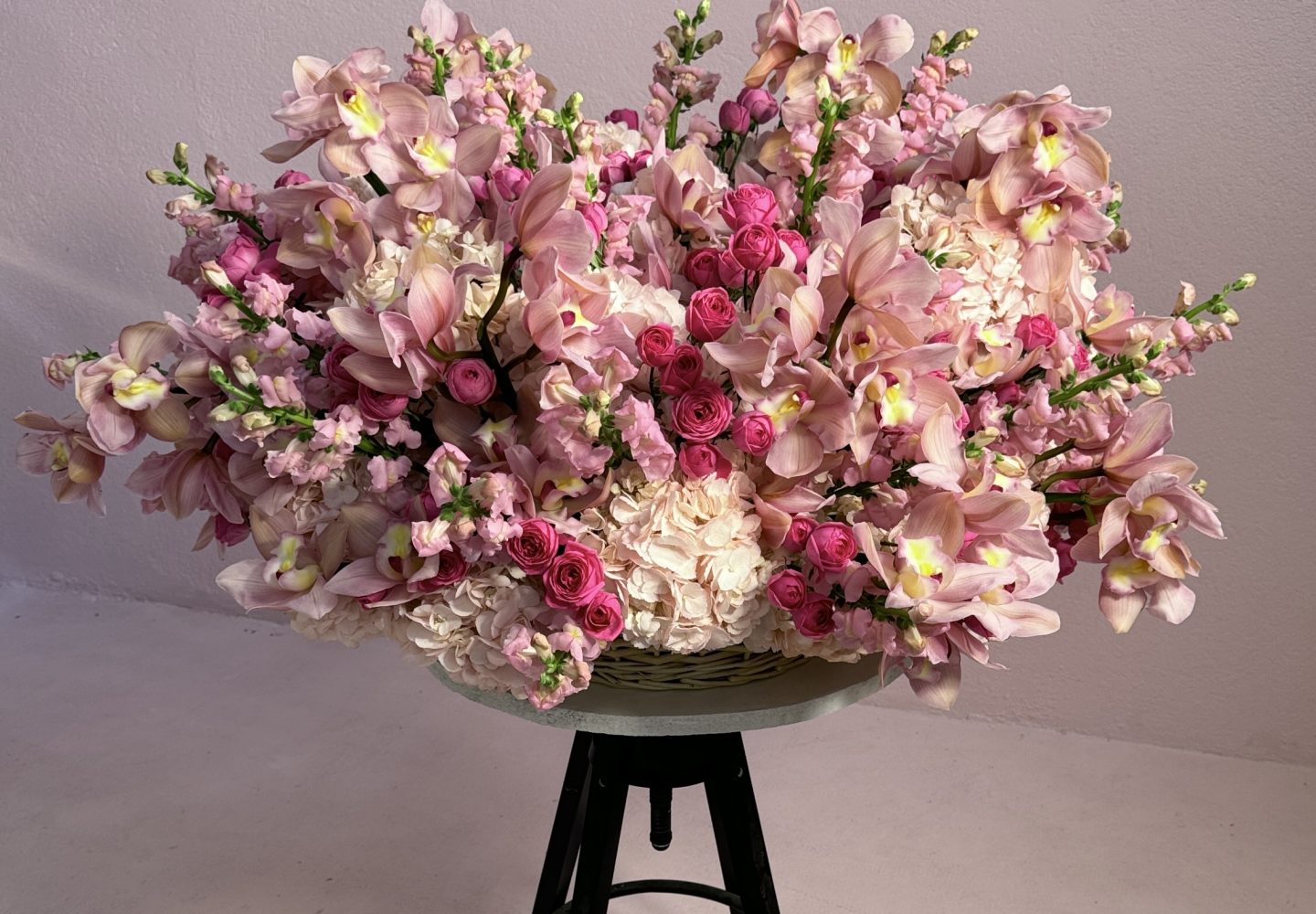 Spray Rose Bouquet featuring pink hydrangeas, cymbidium orchids, and snapdragons in an elegant flower basket