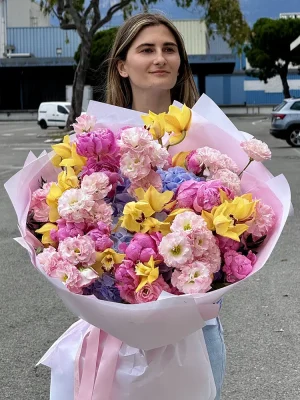 Yellow orchid bouquet featuring vibrant cymbidium orchids, deep pink peonies, light pink lisianthus, and baby blue hydrangea
