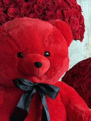 Luxury plush teddy bear with red roses displayed on the French Riviera